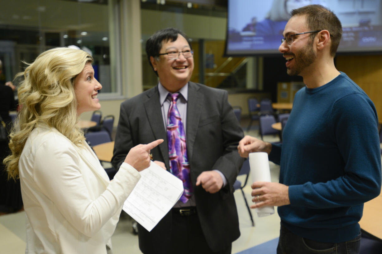 Katie Archer, campaign manager for Bring Vancouver Home, left, speaks to Andy Silver, executive director of the Council for the Homeless, right, and Gary Akizuki, treasurer for Bring Vancouver Home, Tuesday after learning preliminary results of Proposition 1.