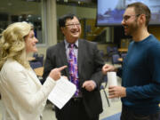 Katie Archer, campaign manager for Bring Vancouver Home, left, speaks to Andy Silver, executive director of the Council for the Homeless, right, and Gary Akizuki, treasurer for Bring Vancouver Home, Tuesday after learning preliminary results of Proposition 1.