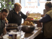 Former Clark County Judge Rich Melnick, center, with his son Ben Melnick, left, and Chuck Chronis, right, serves guests visiting Chronis' Restaurant and Lounge for the annual free Thanksgiving meal in 2013. The elder Melnick and Chronis are teaming with Mark Matthias to revive the tradition after a one-year hiatus, this time at one of Matthias' restaurants, WareHouse '23.