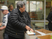 Vancouver Police Activities League volunteer Sandi Glandon assembles a Thanksgiving food bag Tuesday afternoon at the Fruit Valley Community Learning Center in Vancouver.