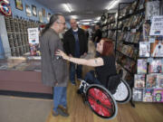 Illustrator Rebecca Woods speaks with Steve Borock, the president of the Comic Book Certification Service, who was among the industry workers Friday who helped raise money for the Battle Ground woman&#039;s new wheelchair at Vancouver&#039;s I Like Comics.