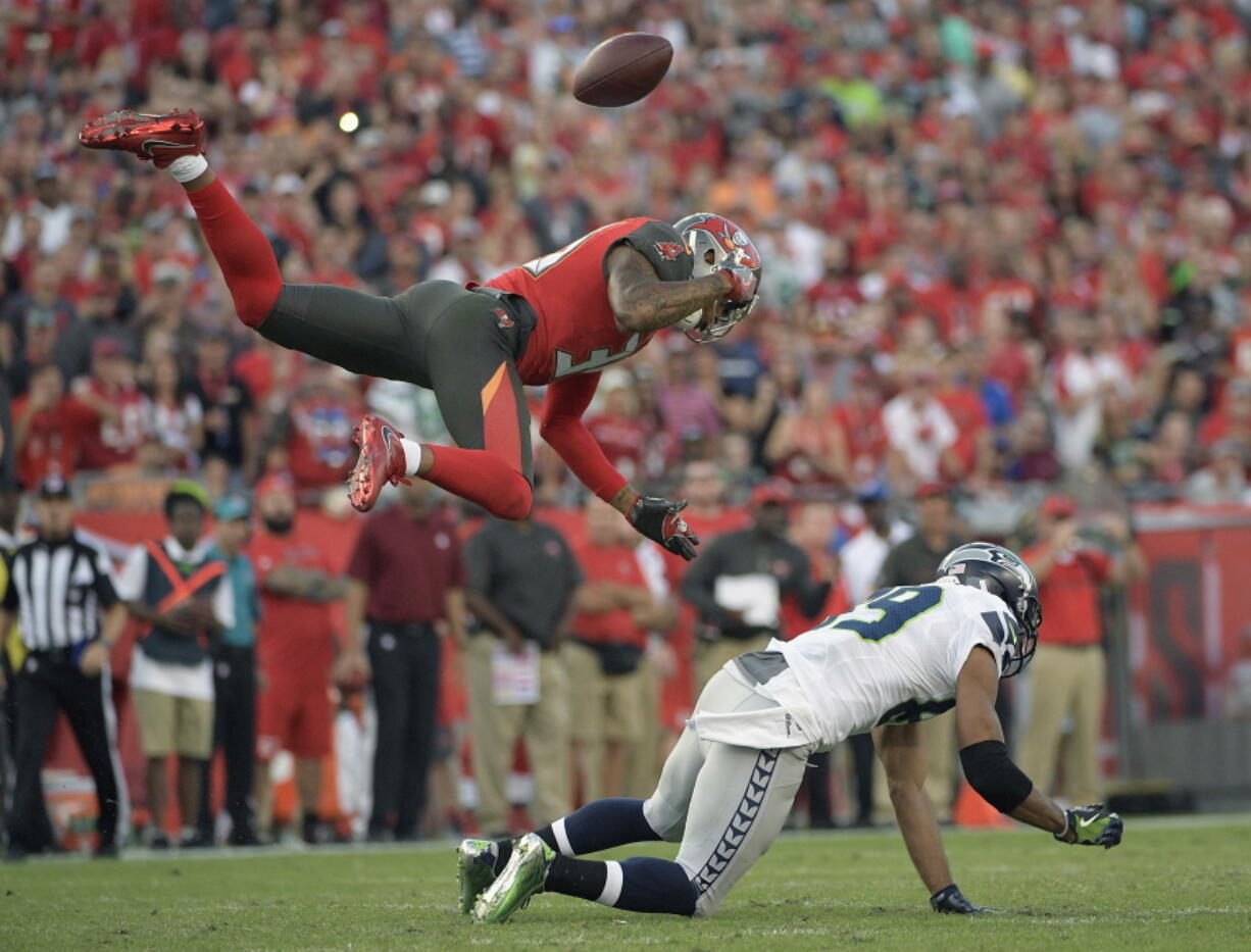 Seattle Seahawks wide receiver Doug Baldwin (89) loses the football as he is hit by Tampa Bay Buccaneers free safety Bradley McDougald (30) during the second quarter of an NFL football game Sunday, Nov. 27, 2016, in Tampa, Fla. McDougald was called for a pass interference penalty.