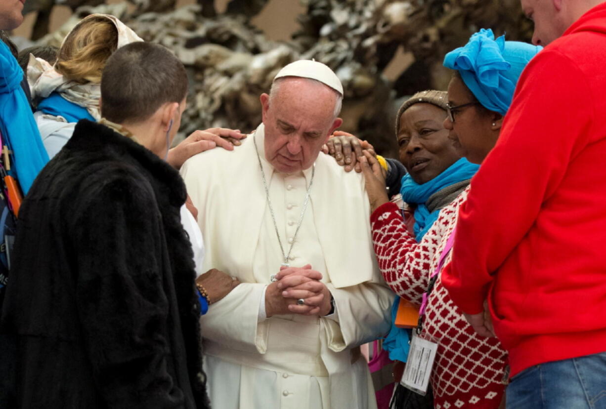 Pope Francis is greeted by faithful Friday during an audience with the participants of homeless jubilee in the Paul VI Hall at the Vatican.