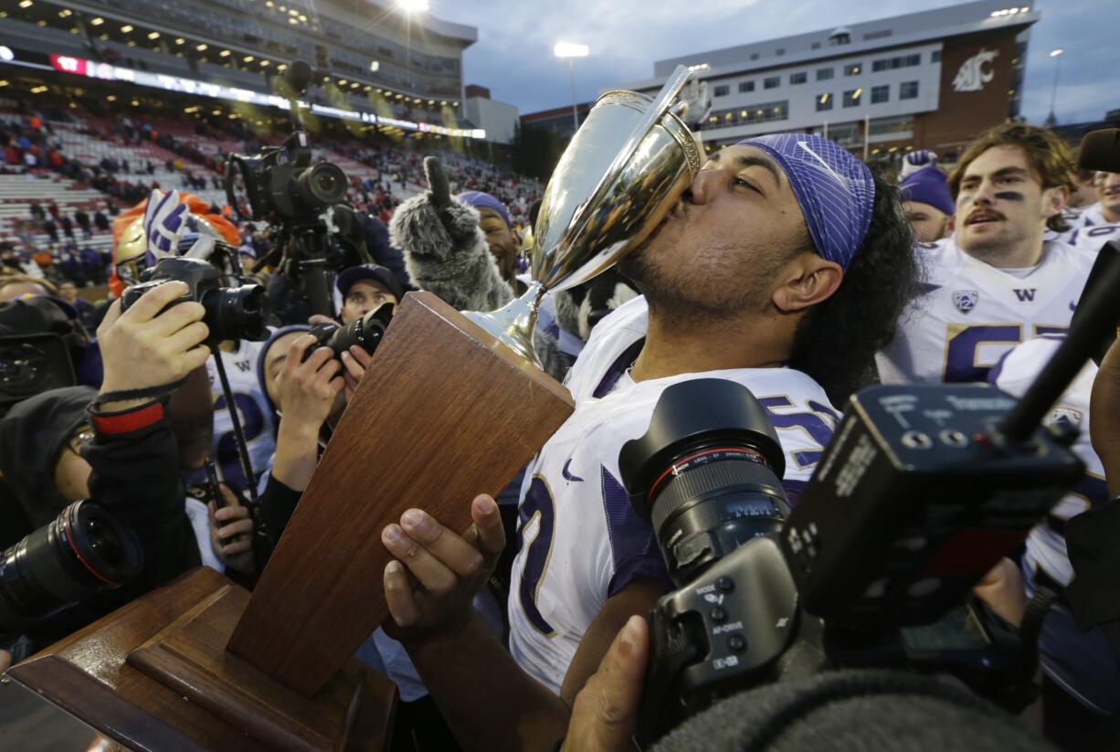 Washington defensive lineman Vita Vea kisses the Apple Cup trophy after Washington beat Washington State, 45-17, in an NCAA college football game, Friday, Nov. 25, 2016, in Pullman, Wash. (AP Photo/Ted S.