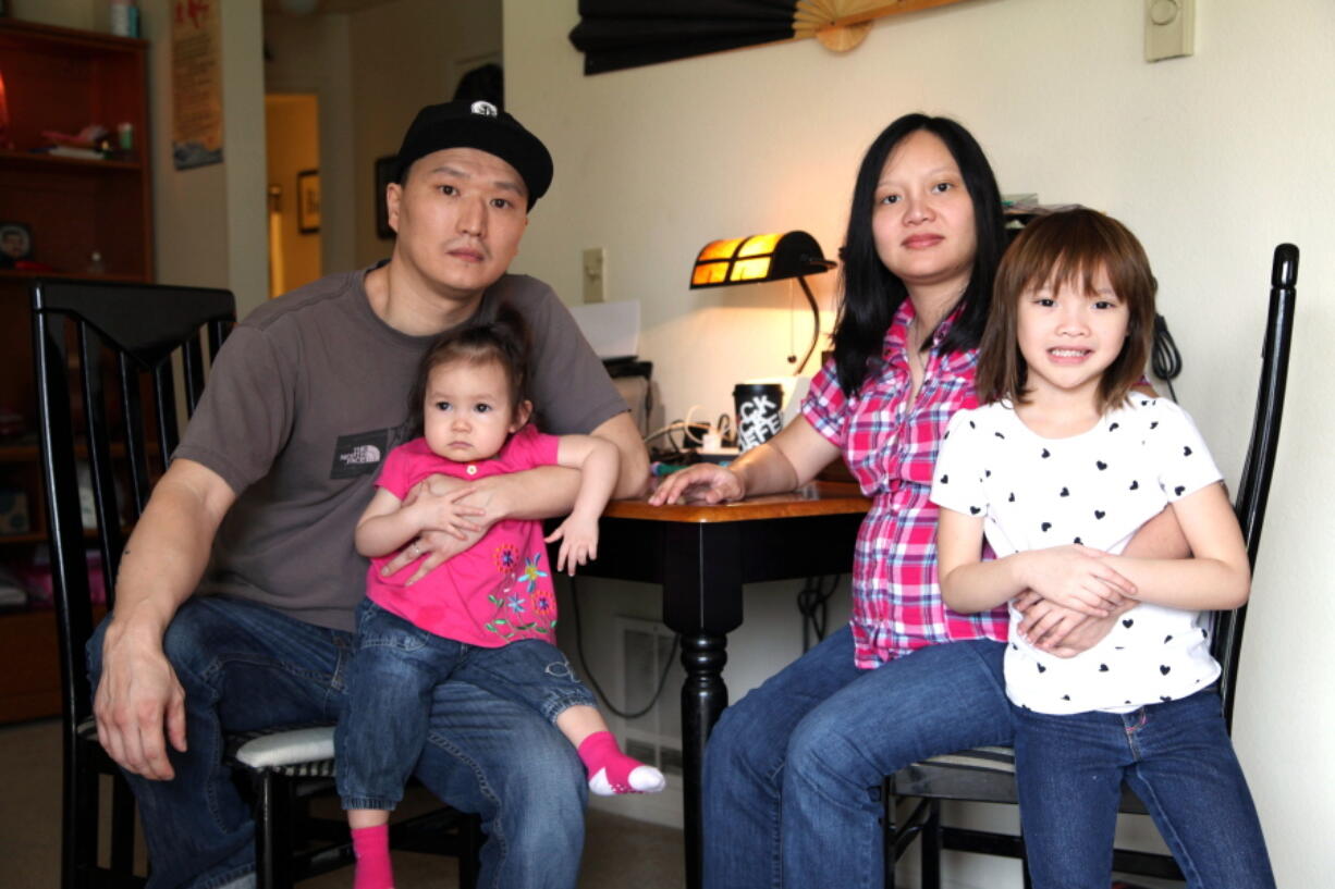 Korean adoptee Adam Crapser, left, poses with daughters, Christal and Christina and his wife, Anh Nguyen, in the family&#039;s living room in Vancouver in 2015. The immigration attorney for Crapser, who was adopted from South Korea almost four decades ago and flown to America, says he has been deported.