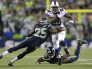 Seattle Seahawks cornerback Richard Sherman, left, tackles Buffalo Bills running back LeSean McCoy on Monday.