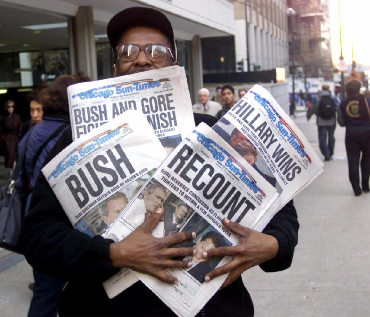 Willie Smith holds four copies of the Chicago Sun-Times, each with a different headline Nov. 8, 2000, in Chicago, reflecting a night of suspense, drama and changes in following the presidential race between Vice President Al Gore and Texas Gov. George W. Bush. What happens if America wakes up on Nov. 9 to a disputed presidential election in which the outcome turns on the results of a razor-thin margin in one or two states, one candidate seeks a recount and the other goes to court?