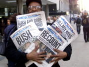 Willie Smith holds four copies of the Chicago Sun-Times, each with a different headline Nov. 8, 2000, in Chicago, reflecting a night of suspense, drama and changes in following the presidential race between Vice President Al Gore and Texas Gov. George W. Bush. What happens if America wakes up on Nov. 9 to a disputed presidential election in which the outcome turns on the results of a razor-thin margin in one or two states, one candidate seeks a recount and the other goes to court?