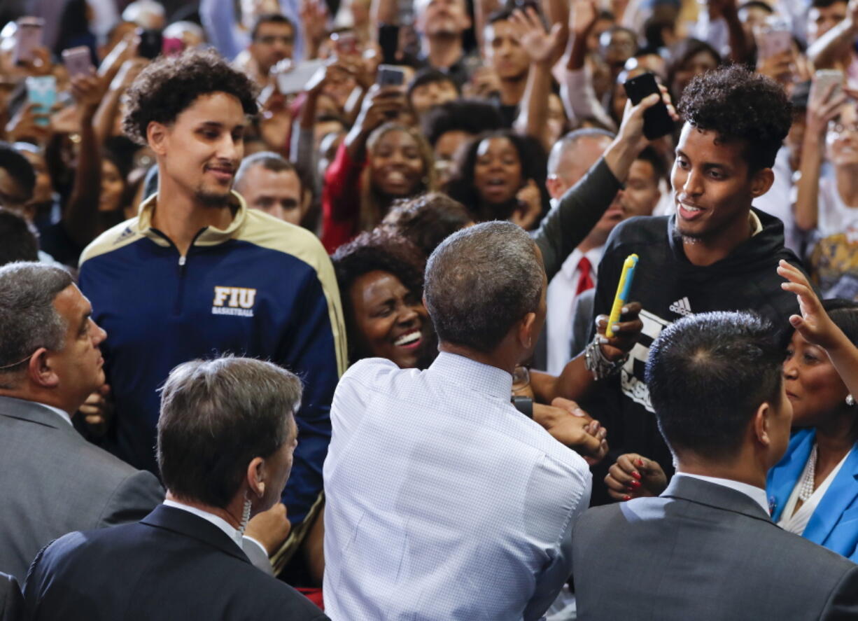 President Barack Obama greets Florida International basketball players Hassan Hussein, right, and Michael Kessens, left, in Miami on Thursday during a campaign rally for Democratic presidential candidate Hillary Clinton.