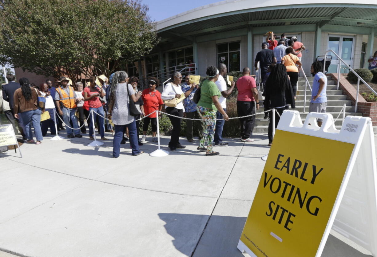 Voters line up during early voting at Chavis Community Center in Raleigh, N.C. More than a dozen states have enacted tougher requirements for registering and voting since the U.S. Supreme Court overturned a key provision of the Voting Rights Act three years ago. That has led to confusion and claims that certain groups, mostly minorities who tend to vote with Democrats, are being disenfranchised.