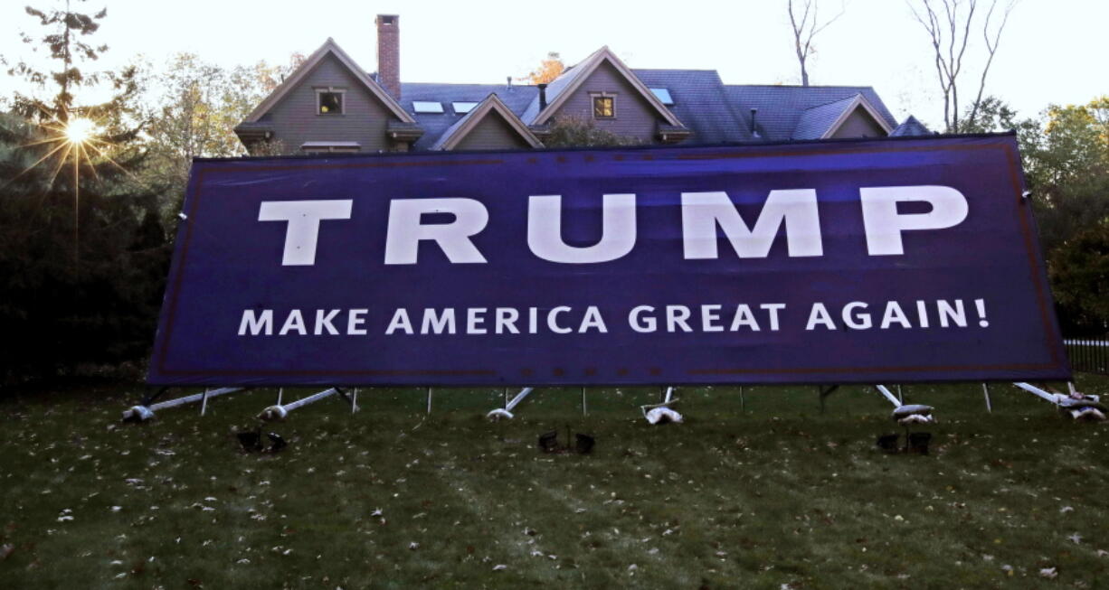 As the sun sets, a giant Trump campaign yard sign nearly dwarfs the Antico family, six-bedroom home in Wayland, Mass., Tuesday, Nov. 1, 2016. The sign, which was erected in early Spring 2016, is about fifty feet long. Campaign signs have been a thing since the early 1800s. Political scientists question the effectiveness of yard signs, at least in presidential politics.