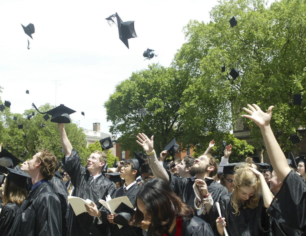 Brown University graduates throw their caps into the air at the conclusion of graduation ceremonies in Providence, R.I.