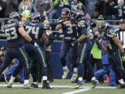 Seattle Seahawks quarterback Russell Wilson (3) is greeted by teammates after Wilson caught a pass from Seahawks' wide receiver Doug Baldwin for a touchdown against the Philadelphia Eagles in the second half of an NFL football game, Sunday, Nov. 20, 2016, in Seattle.