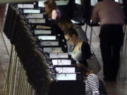 People vote at a polling station on the first day of early voting in Miami-Dade County for the general election Monday in Miami.