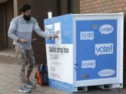 Jared Keirn deposits his vote-by-mail ballot in a collection box, Thursday, Nov. 3, 2016, at Seattle Central College in Seattle. More than a million Washingtonians have already cast their ballots in advance of Tuesday's election, as voters decide on federal and state races, as well as ballot initiatives. (AP Photo/Ted S.