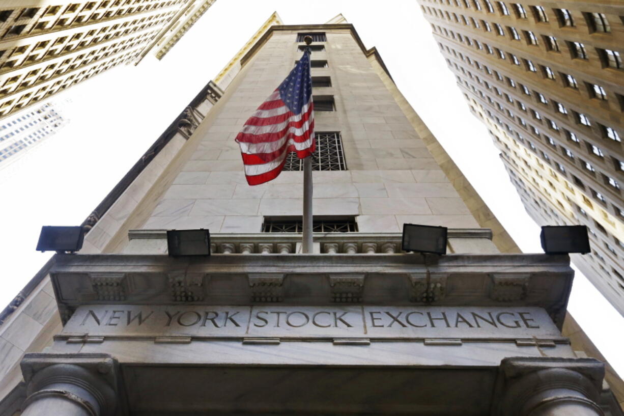 The American flag flies above the Wall Street entrance to the New York Stock Exchange. Global stock markets were steady Tuesday, Nov. 8, 2016, following strong Wall Street gains the day before, as investors focused on the final hours of a tight U.S. presidential race.