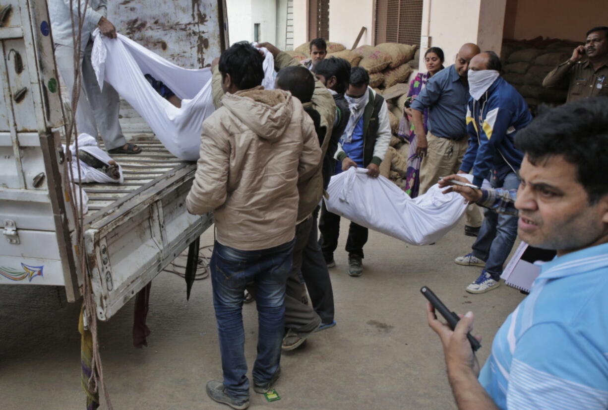 Relatives take away bodies of a train accident victims after identifying them from a cold storage used for storing potatoes in Kanpur Dehat district, northern Uttar Pradesh state, India, on Monday. Several bodies had to be kept in this cold storage since the hospital mortuaries ran out of space following the accident. Dozens died and dozens more were injured when an overnight passenger train rolled off the track at 3:10 a.m. Sunday.