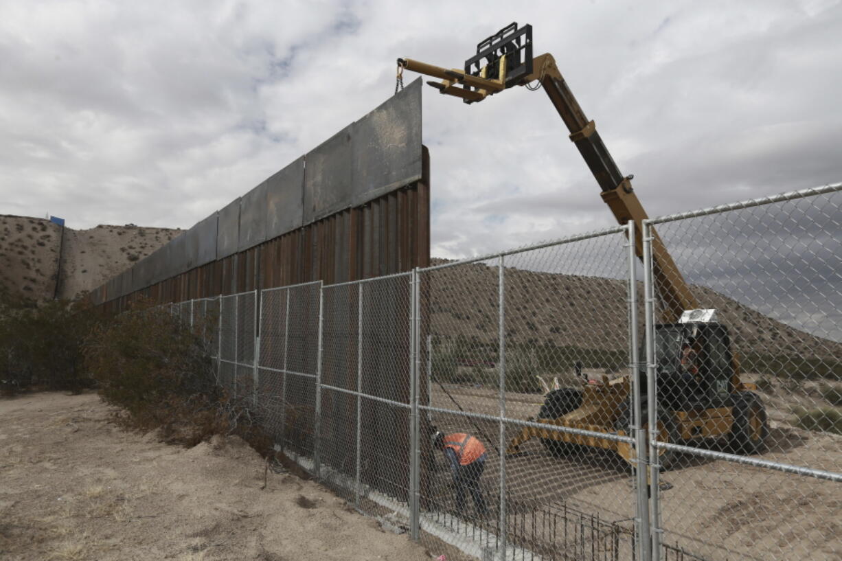 Workers continue work Thursday raising a taller fence in the Mexico-U.S. border area separating the towns of Anapra, Mexico and Sunland Park, New Mexico. Last September, the U.S. Border Patrol began erecting an 18-foot-tall steel fence in this area considered very symbolic to immigration activists and also the site where, for the past 17 years, a binational Mass celebrating Mexico&#039;s Day of the Dead is held to honor the migrants who have died trying to get to the United States.