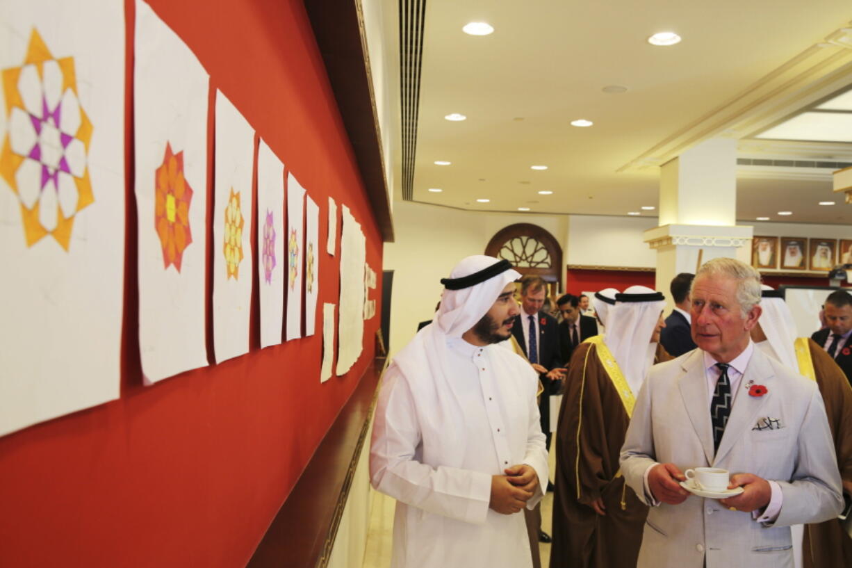 Britain&#039;s Prince Charles looks at student artwork at the Isa Cultural Center in Manama, Bahrain, on Thursday. Prince Charles and his wife Camilla are on a three-nation tour of the Gulf.