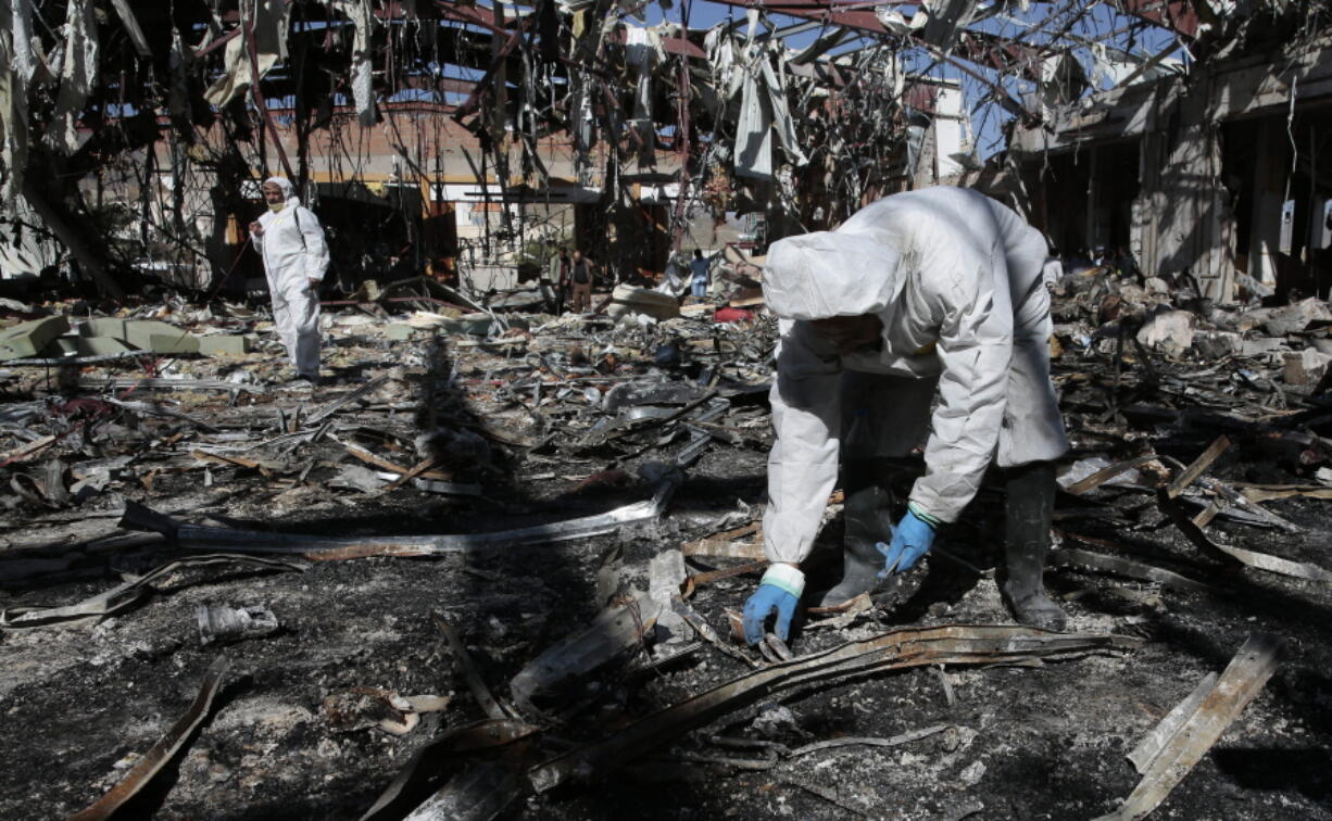 Forensics experts gather evidence Oct. 10 in the rubble of a funeral hall destroyed by a deadly Saudi-led airstrike on Oct. 8 in Sanaa, Yemen. Experts say some of the strikes likely amount to war crimes.