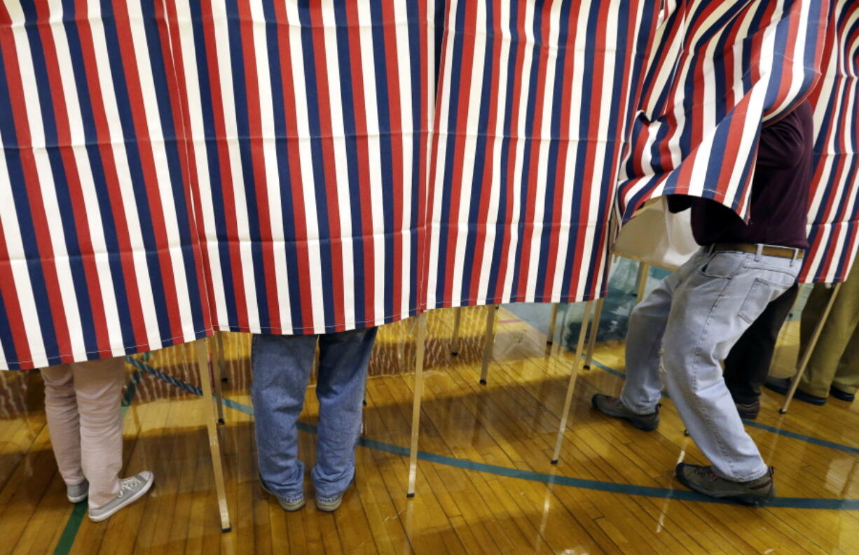 FILE - In this Nov. 8, 2016 file photo, a voter enters a booth at a polling place in Exeter, N.H. On Sunday, Nov.