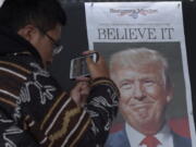 Zheng Gao of Shanghai, China, photographs the front pages of newspapers on display Wednesday outside the Newseum in Washington, D.C., the day after Donald Trump won the presidency.