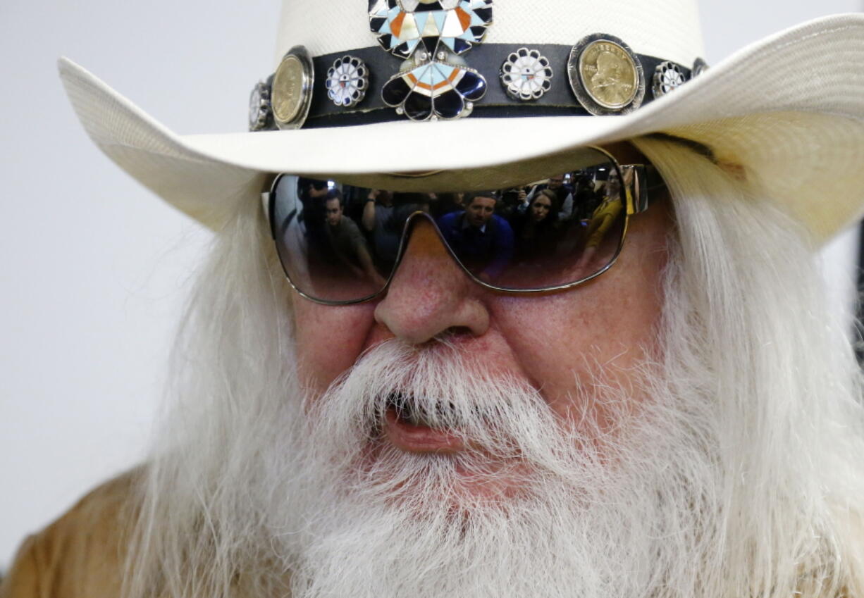 FILE - In this Jan. 29, 2013, file photo, reporters are reflected in the sunglasses of Leon Russell as he answers a question at a news conference in Tulsa, Okla. Russell, who sang, wrote and produced some of rock &#039;n&#039; roll&#039;s top records, has died.