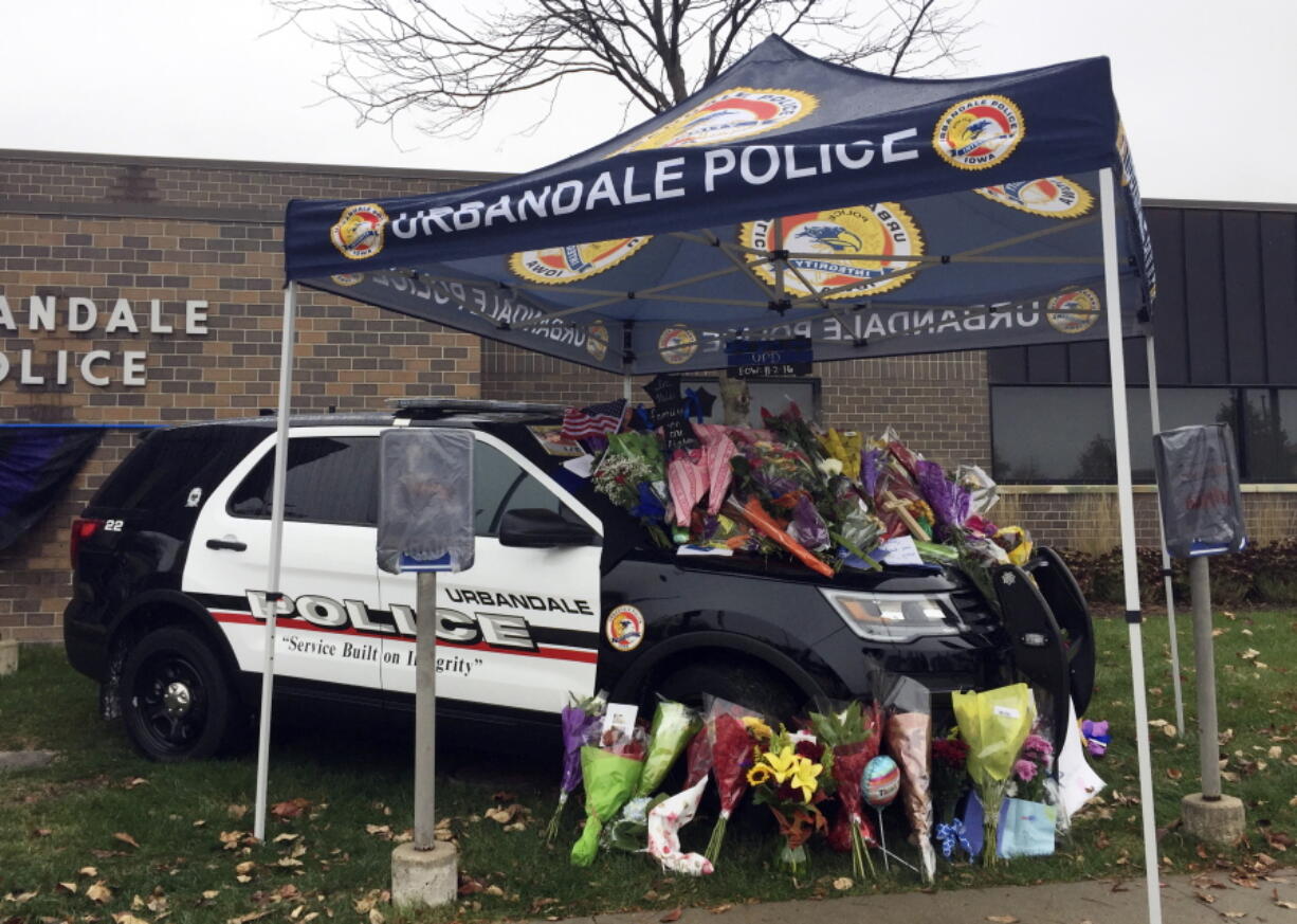 Items are left at a memorial outside the police department in Urbandale, Iowa, for two police officers shot to death Wednesday morning.