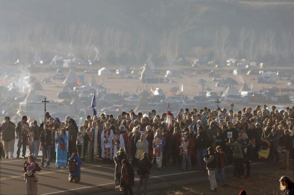 A long procession of hundreds clergy of numerous denominations and faiths walk on Highway 1806 from the Oceti Sakowin encampment to the site of the violent clash with law enforcement with Dakota Access Pipeline protesters Nov. 3, 2016 in Morton County, N.D.