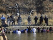 Protesters demonstrating against the expansion of the Dakota Access Pipeline wade in cold creek waters confronting local police as remnants of pepper spray waft over the crowd near Cannon Ball, N.D. The U.S. Army Corps of Engineers says it&#039;s trying to diffuse tensions between pipeline protesters and law enforcement in North Dakota, but that the pipeline&#039;s developer isn&#039;t cooperating. (AP Photo/John L.