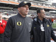 Oregon head coach Mark Helfrich, center, comes onto the field for an interview before an NCAA college football game against Oregon State, in Corvallis, Ore., Saturday Nov. 26, 2016. (AP Photo/Timothy J.