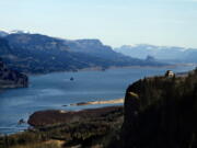 The Columbia River flows past the Vista House on Crown Point, right, with Beacon Rock visible in the distance near Corbett, Ore. Oregon is expecting a record number of visits to its state parks and federal lands for the second year in a row. Data from multiple agencies shows that the crowds began growing in 2013 and show no signs of slowing down.