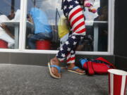 A woman, wearing a Stars and Stripes-designed pants, cuddles her baby outside an American fast food chain Tuesday in Manila, Philippines. The Philippines as in most of the countries around the world are watching the U.S. presidential election pitting Democrat Hillary Clinton against Republican Donald Trump.