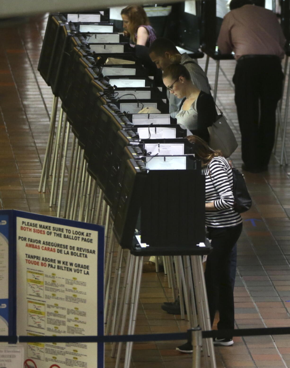 People vote at a polling station on the first day of early voting in Miami-Dade County for the general election in Miami.