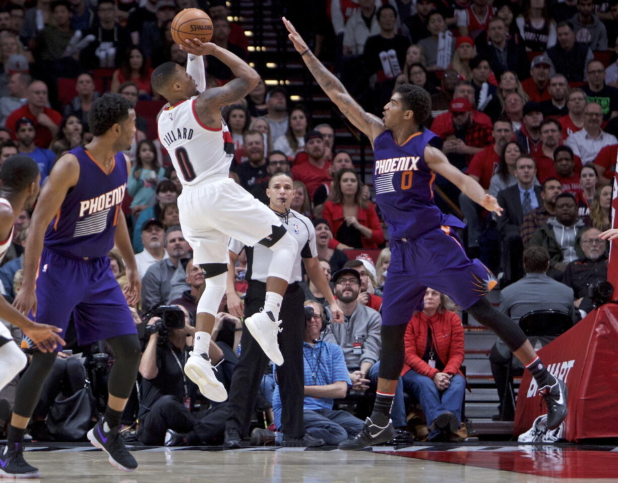 Portland Trail Blazers guard Damian Lillard, left, shoots over Phoenix Suns forward Marquese Chriss during the second half of an NBA basketball game in Portland, Ore., Tuesday, Nov. 8, 2016. The Trail Blazers won 124-121.