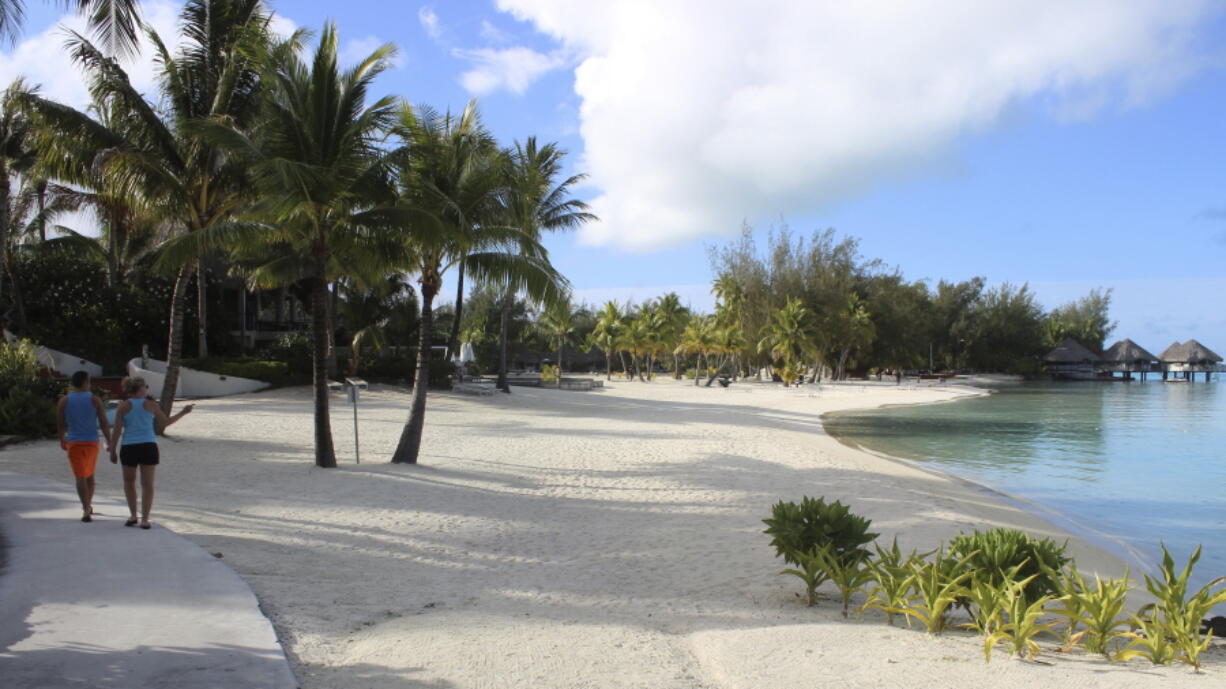 A couple stroll along the sidewalk Nov. 1 next to the beach at Le Meridien resort in Bora Bora. Bora Bora is 160 miles from Tahiti, with a balmy and relatively consistent temperature of 80 degrees.