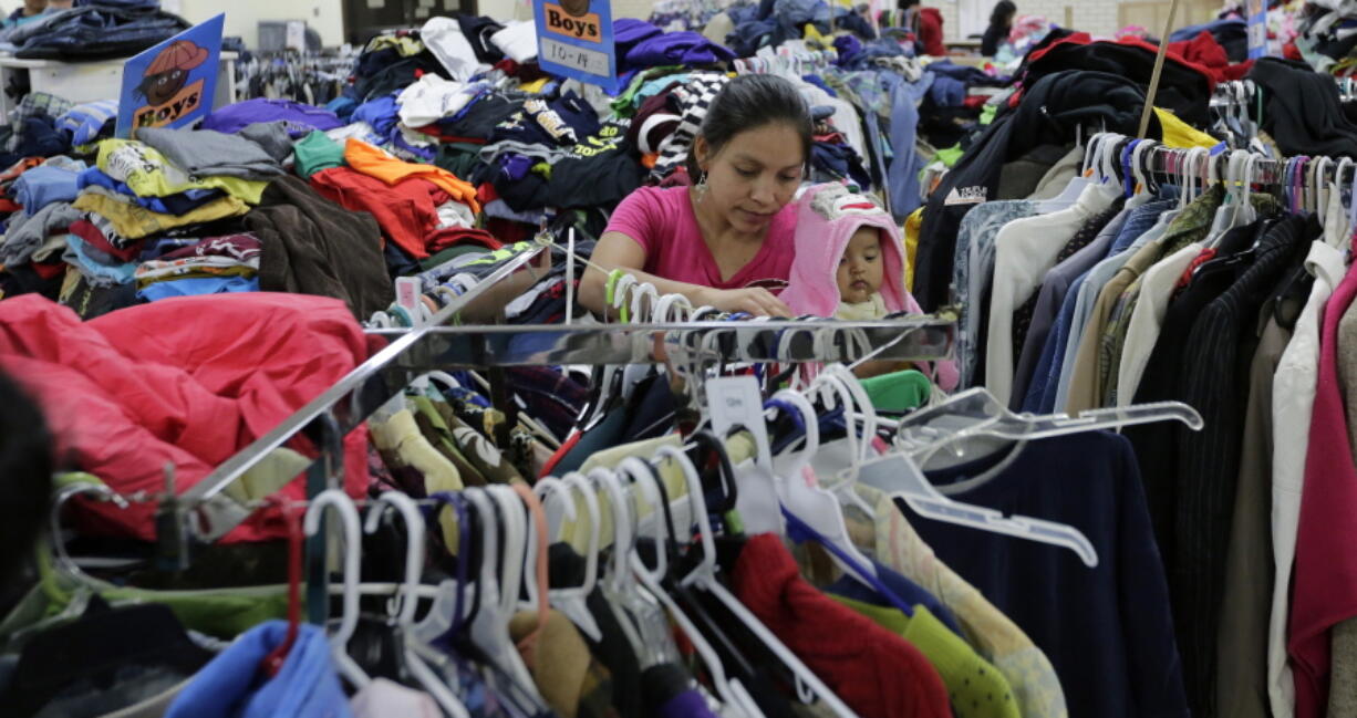 Central American migrants newly released after processing by the U.S. Customs and Border Patrol look for clothing at the Sacred Heart Community Center in the Rio Grande Valley border city of McAllen, Texas, on Sunday. President-elect Donald Trump is starting to sound a lot more like President Barack Obama on his stance on immigration and easing his pledge to build a wall across the Mexican border.