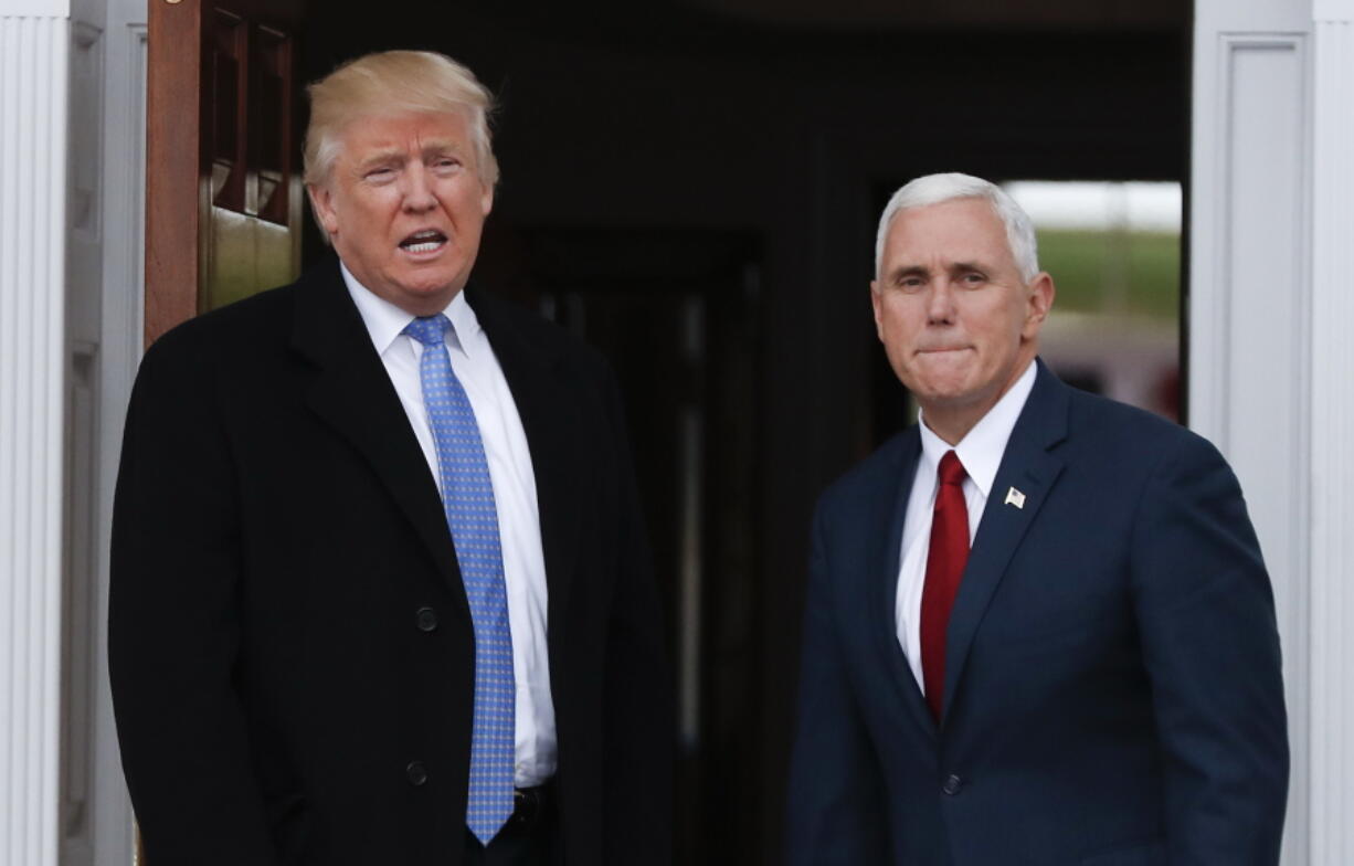 President-elect Donald Trump, left, talks to media as he and Vice President-elect Mike Pence arrive at the Trump National Golf Club Bedminster clubhouse Sunday in Bedminster, N.J..