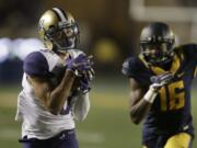 Washington's Dante Pettis, left, runs past California's Chibuzo Nwokocha (16) for a touchdown Saturday (BEN MARGOT/Associated Press)