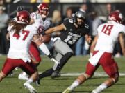 Colorado quarterback Sefo Liufau, center, runs for a short gain as Washington State linebacker Peyton Pelluer, defensive lineman Hercules Mata'afa and safety Shalom Luani close in for a stop in the first half of an NCAA college football game, Saturday, Nov. 19, 2016, in Boulder, Colo.