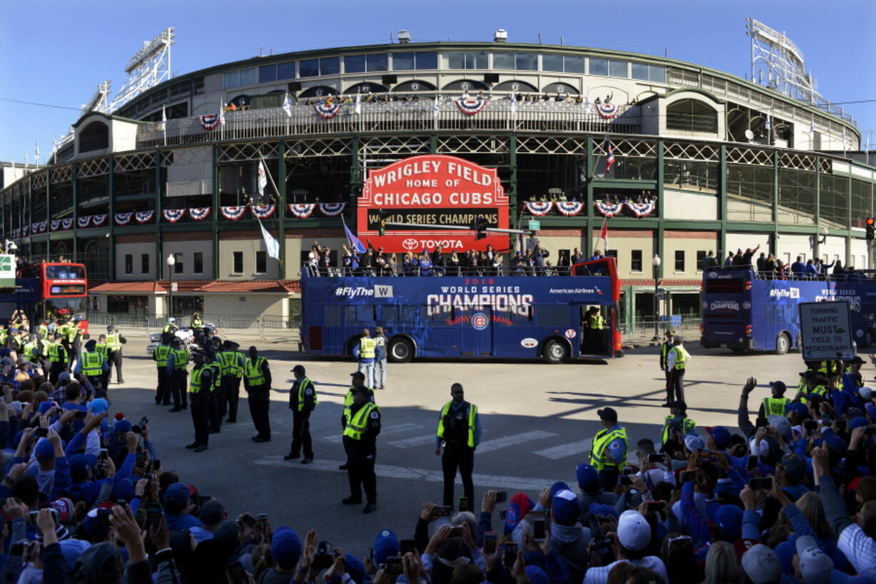 A parade honoring the World Series champion Chicago Cubs passes Wrigley Field Friday, Nov. 4, 2016, in Chicago.