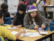 Fifth-graders Kaiah Satcher, left, and Courtney Butler, both 10, decorate letters to adult pen pals paired with them through the RSVP Pen Pal Program run by Volunteer Connections at Burnt Bridge Creek Elementary School on Tuesday morning. The program is looking for adult volunteers to write letters so it can add more students and schools.