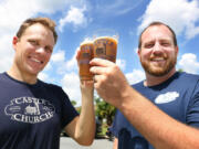 Jared Witt, left, and Aaron Schmalzle, co-founders of Castle Church Brewing Community, hoist some micro-brewed beers outside Schmalzle&#039;s Kissimmee, Fla. home. They plan to open a brew pub in downtown Orlando in coalition with their Lutheran faith. (Stephen M.