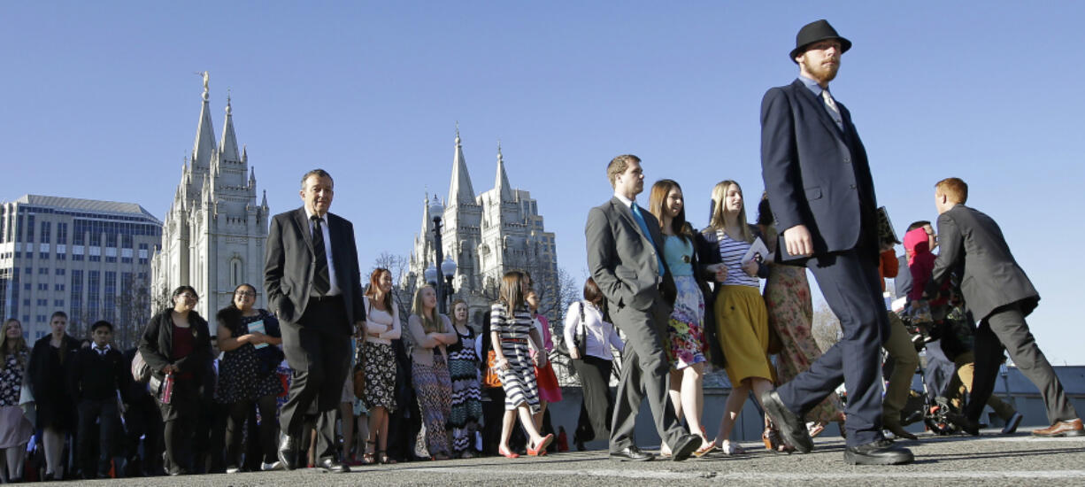 People walk near the Salt Lake Temple on the way to the opening session for the semiannual General Conference of The Church of Jesus Christ of Latter-day Saints on April 2 in Salt Lake City. A former member of the church has launched a Mormon WikiLeaks website.