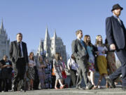 People walk near the Salt Lake Temple on the way to the opening session for the semiannual General Conference of The Church of Jesus Christ of Latter-day Saints on April 2 in Salt Lake City. A former member of the church has launched a Mormon WikiLeaks website.