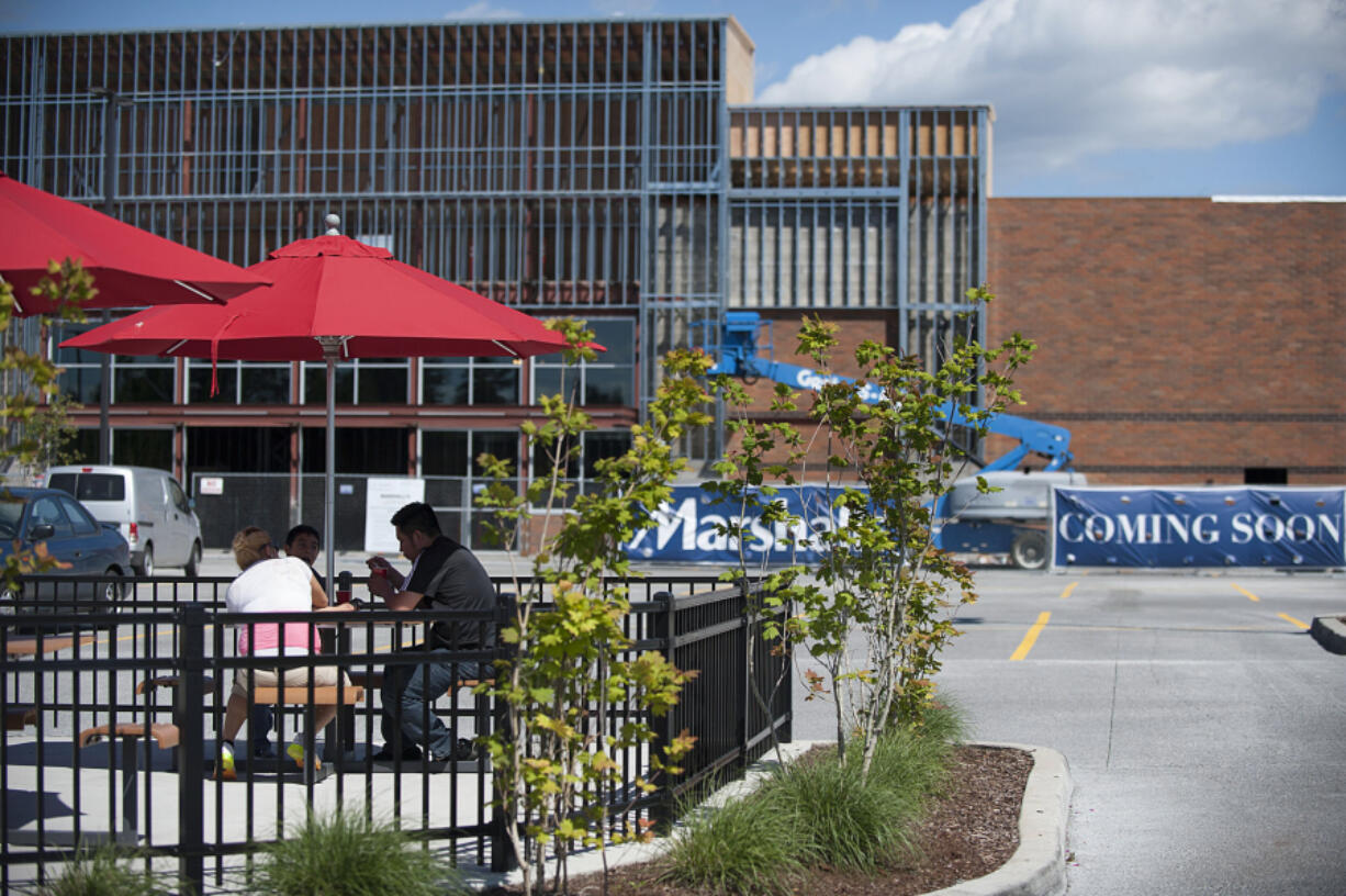 Customers grab a bite to eat at Wendy&#039;s while sitting in their outdoor dining area as construction is seen at the new Marshalls store nearby in May at Hazel Dell Marketplace. TJX Cos., which owns Marshalls, is the rare retailer that doesn&#039;t worry about online sales.