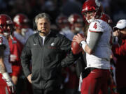 Washington State head coach Mike Leach, left, confers with quarterback Luke Falk during an injury time out against Colorado in the first half of an NCAA college football game, Saturday, Nov. 19, 2016, in Boulder, Colo.