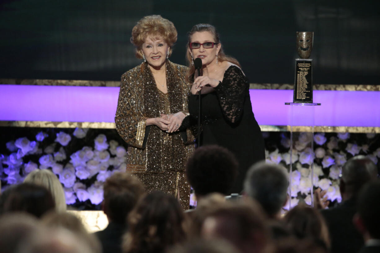 Carrie Fisher presents the Life Achievement Award to Debbie Reynolds at the 21st Annual Screen Actors Guild Awards on Sunday, Jan. 25, 2015, at the Shrine Auditorium in Los Angeles.