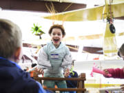 Cora Philippson, 8, tests her green paper whirligig over a vertical wind table and strands of her hair go along for the ride Tuesday during the winter-break camp at the Pearson Field Education Center.