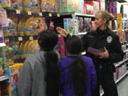 Battle Ground: Battle Ground Police Sgt. Kimberly Armstrong talks with student shoppers during the department&#039;s third annual Shop with a Cop event on Dec.